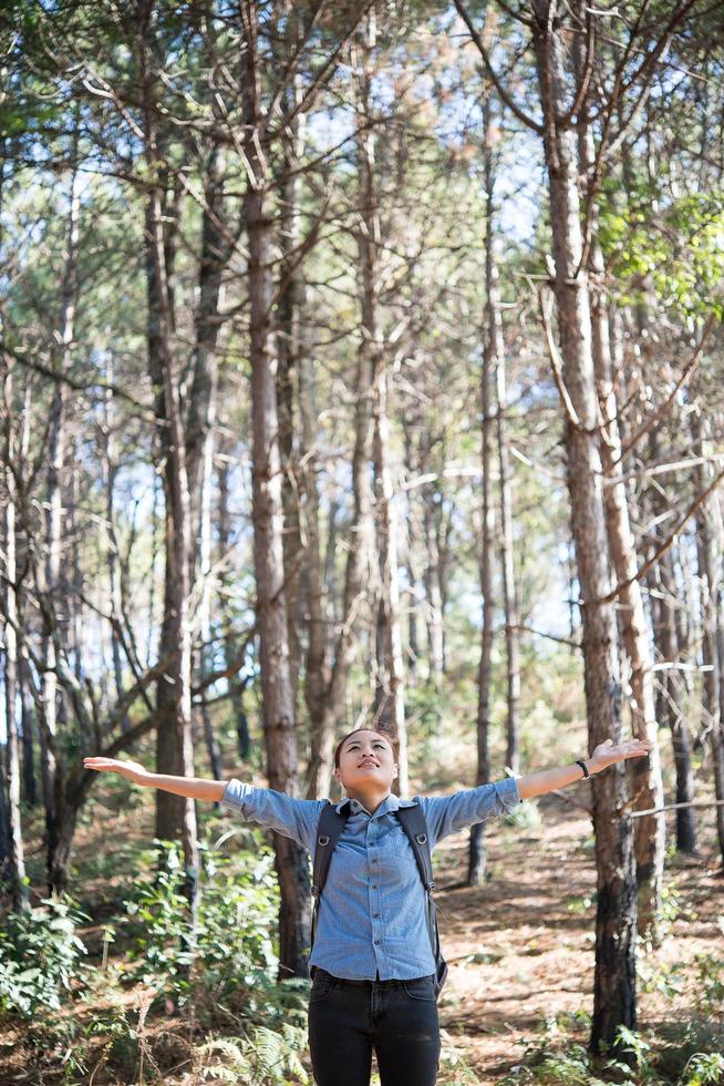 Young hipster woman enjoying nature with outstretched arms photo