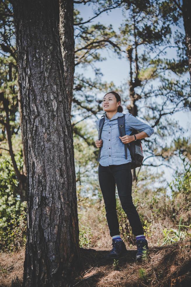 mujer joven que viaja con una mochila en la naturaleza foto