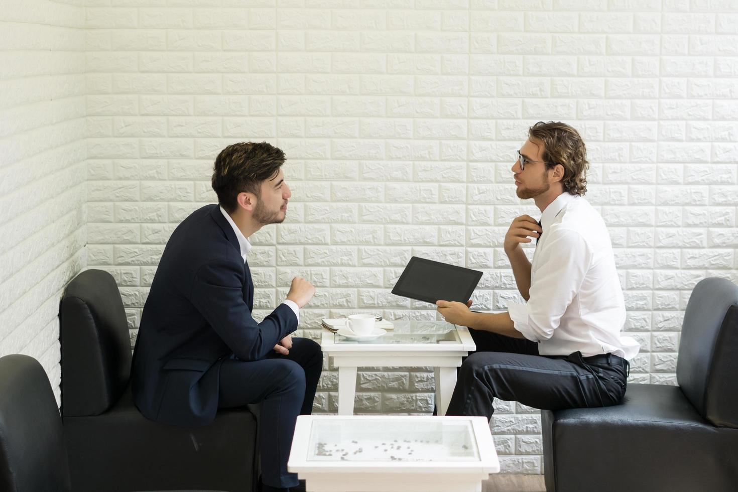 Young businessman talking with colleague in a modern business lounge photo