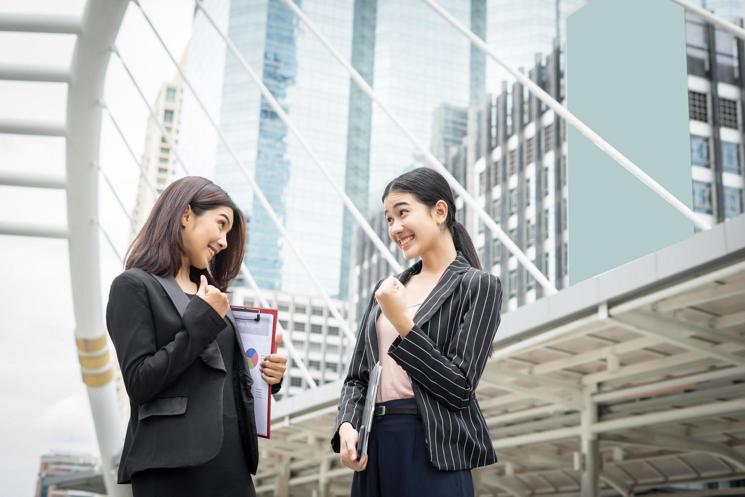 Dos mujeres empresarias se ponen de pie y discuten el trabajo frente a la oficina. foto