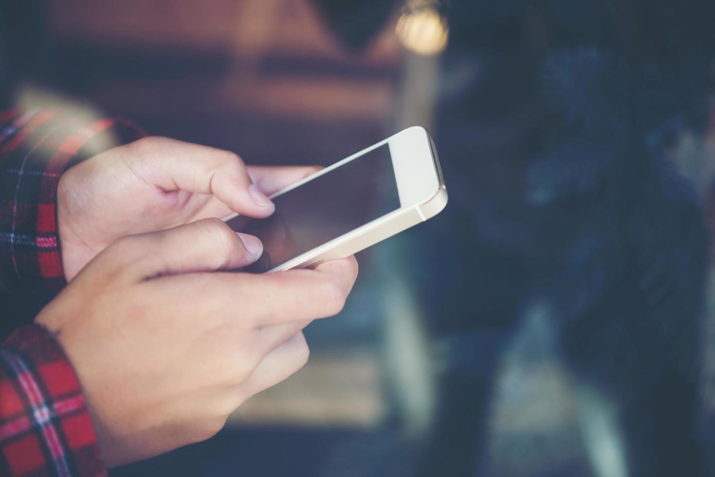 Close-up of woman holding a cell phone with reflection from window photo