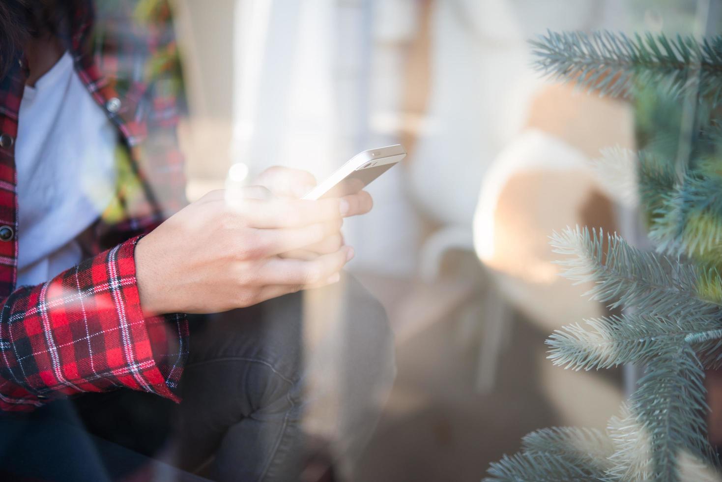 Close-up of woman holding a cell phone with reflection from window photo