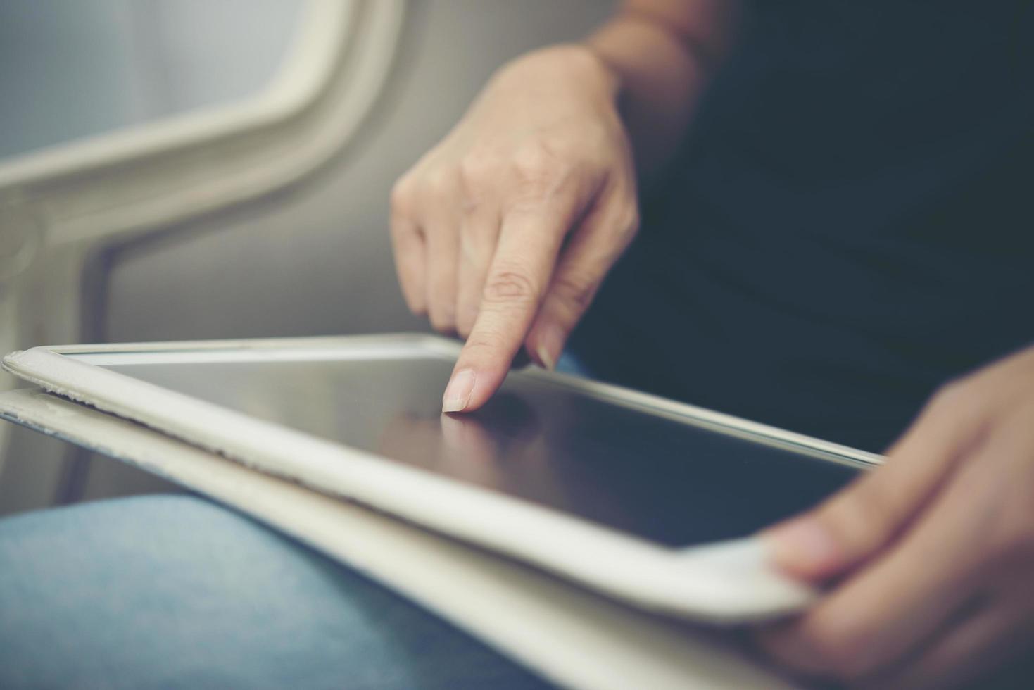 Close-up of hands using tablet sitting and relaxing photo