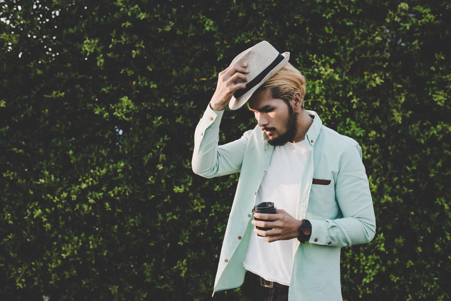Happy hipster man holding hot coffee photo