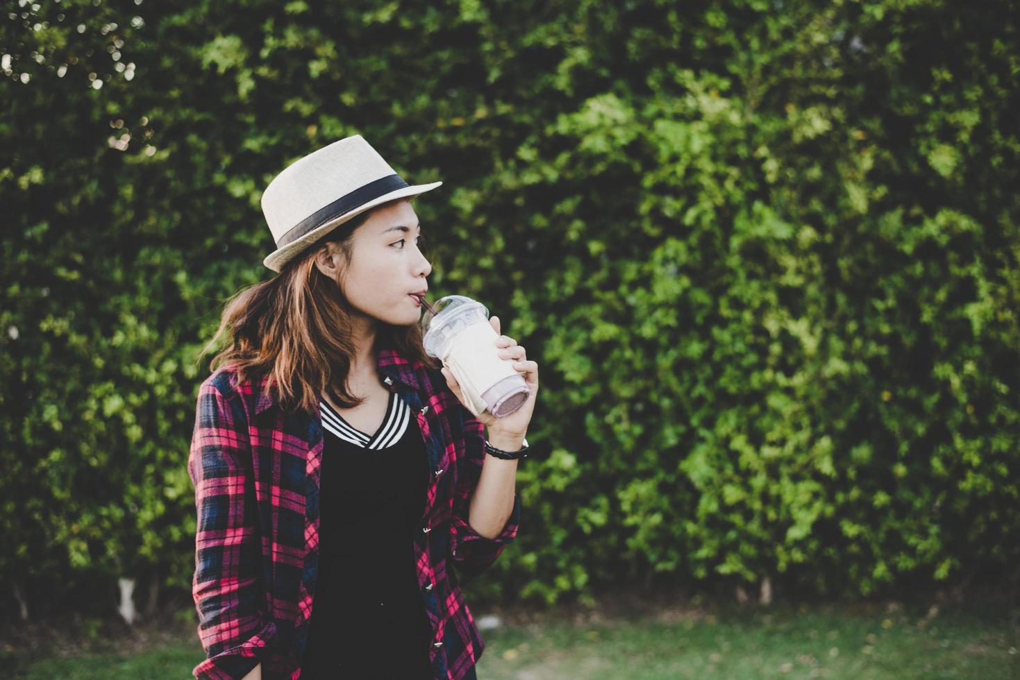 Beautiful hipster woman drinking a milkshake outdoors photo