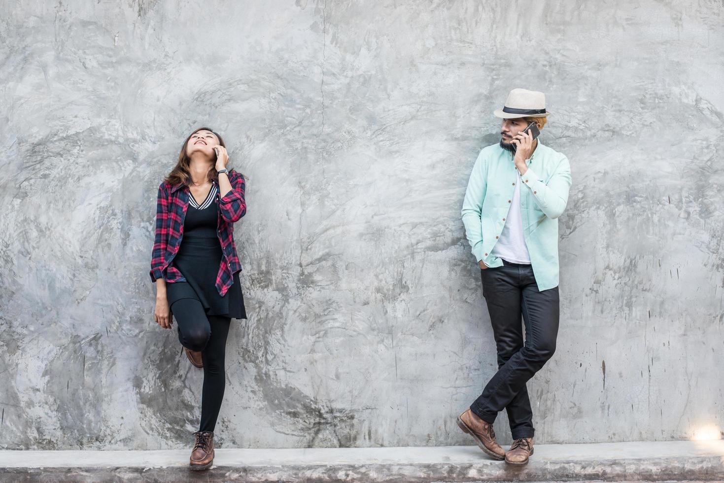 Couple talking to mobile on brick wall, vintage, grunge background photo