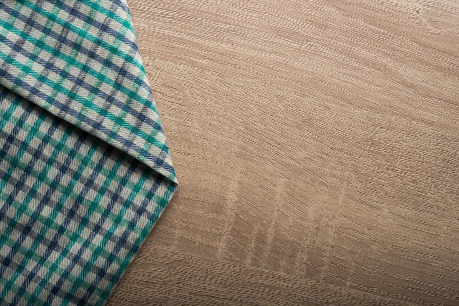 Checkered green napkin on a wooden background photo