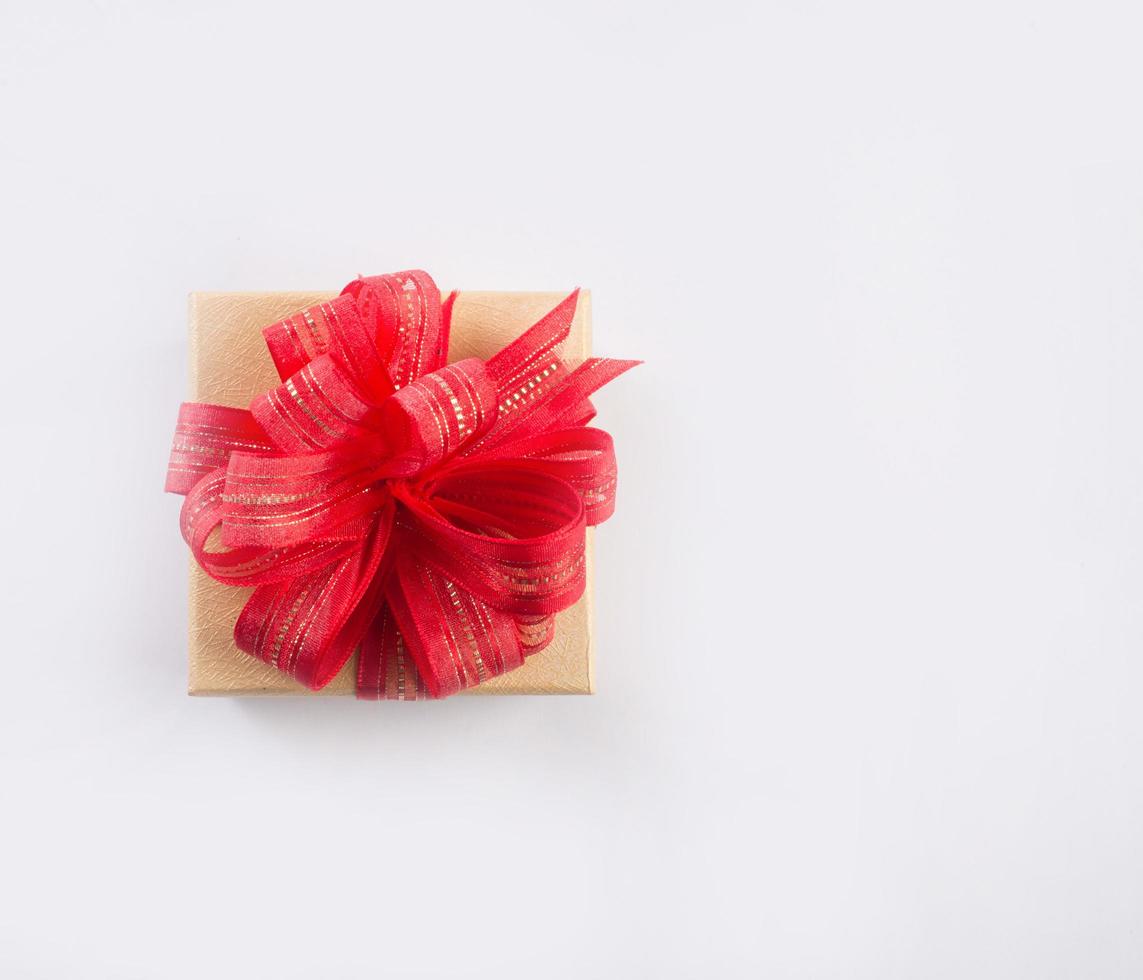 Caja de regalo con un lazo aislado sobre fondo blanco. foto