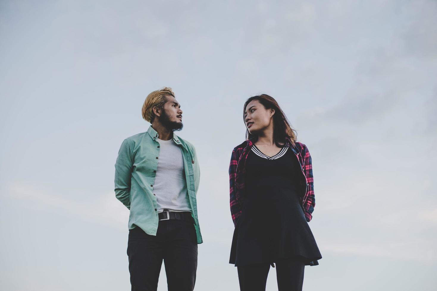 Loving hipster couple standing against clear sky photo