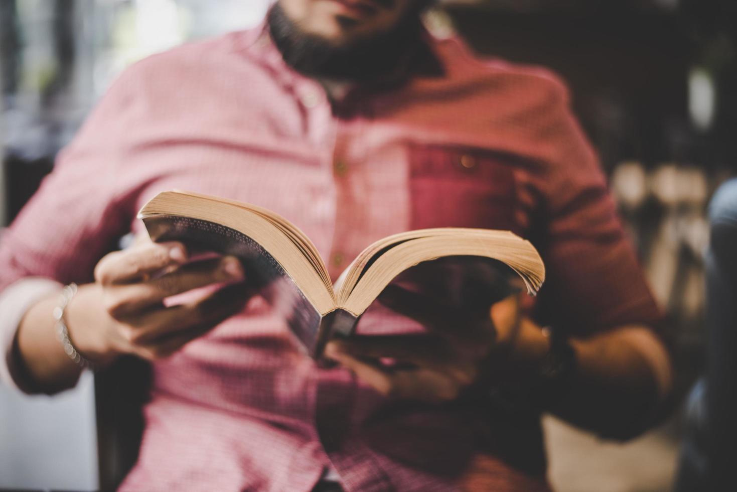 hipster barbudo libro de lectura en la cafetería. foto