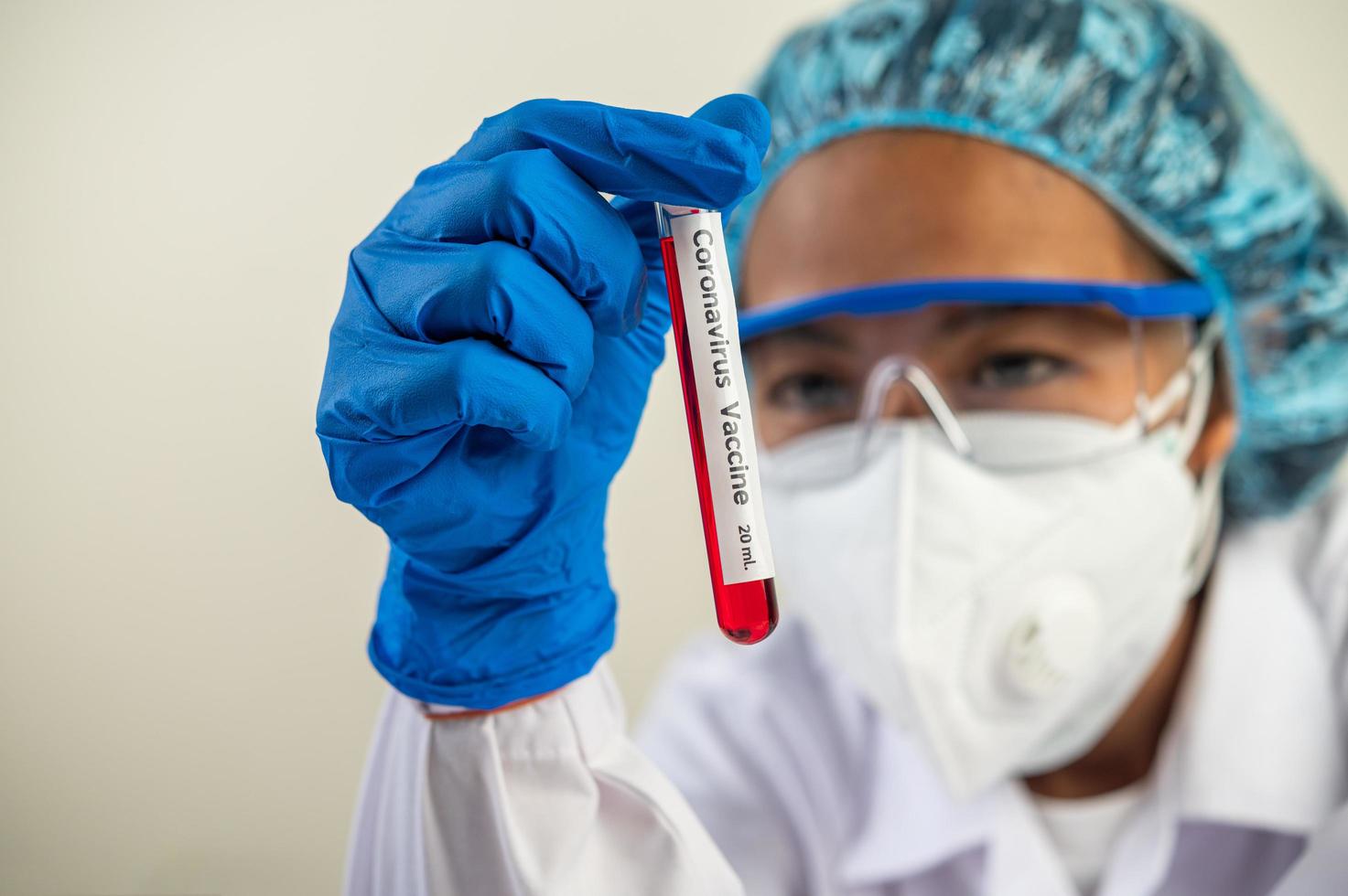 Scientist wearing gloves and holding beakers photo