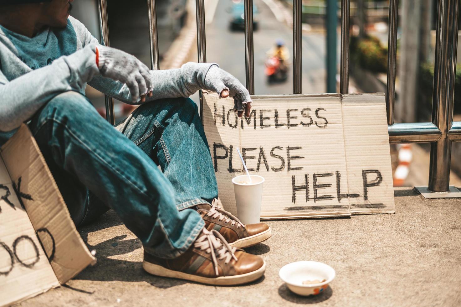 Man sitting begging on an overpass photo