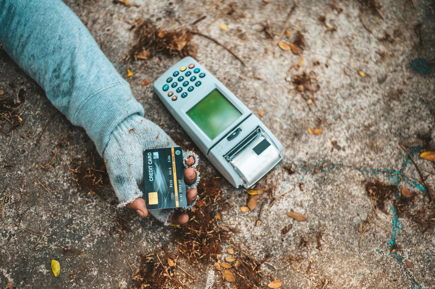 mendigo duerme en la calle con máquina de tarjeta de crédito foto