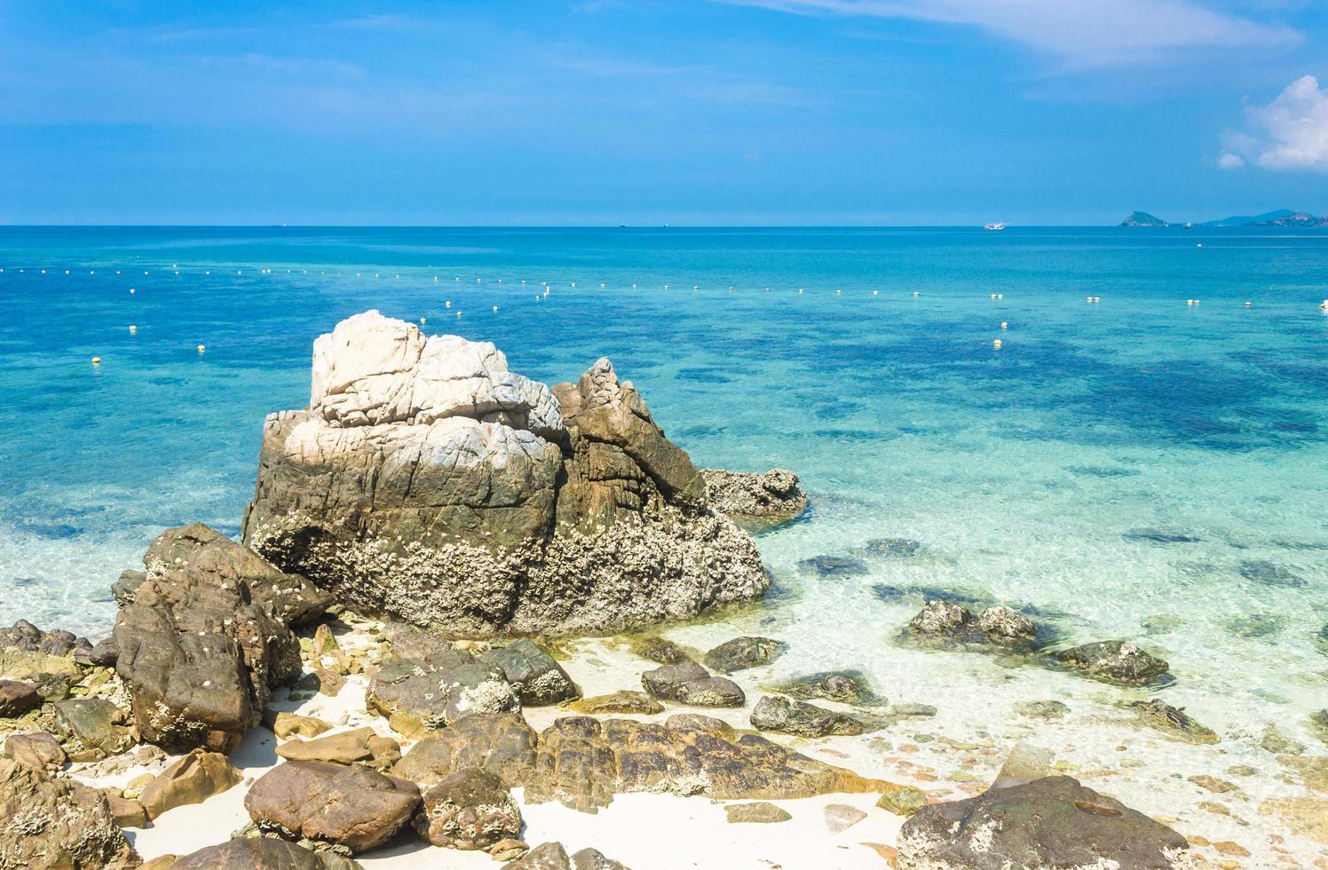 Tropical island rock on the beach with cloudy blue sky photo