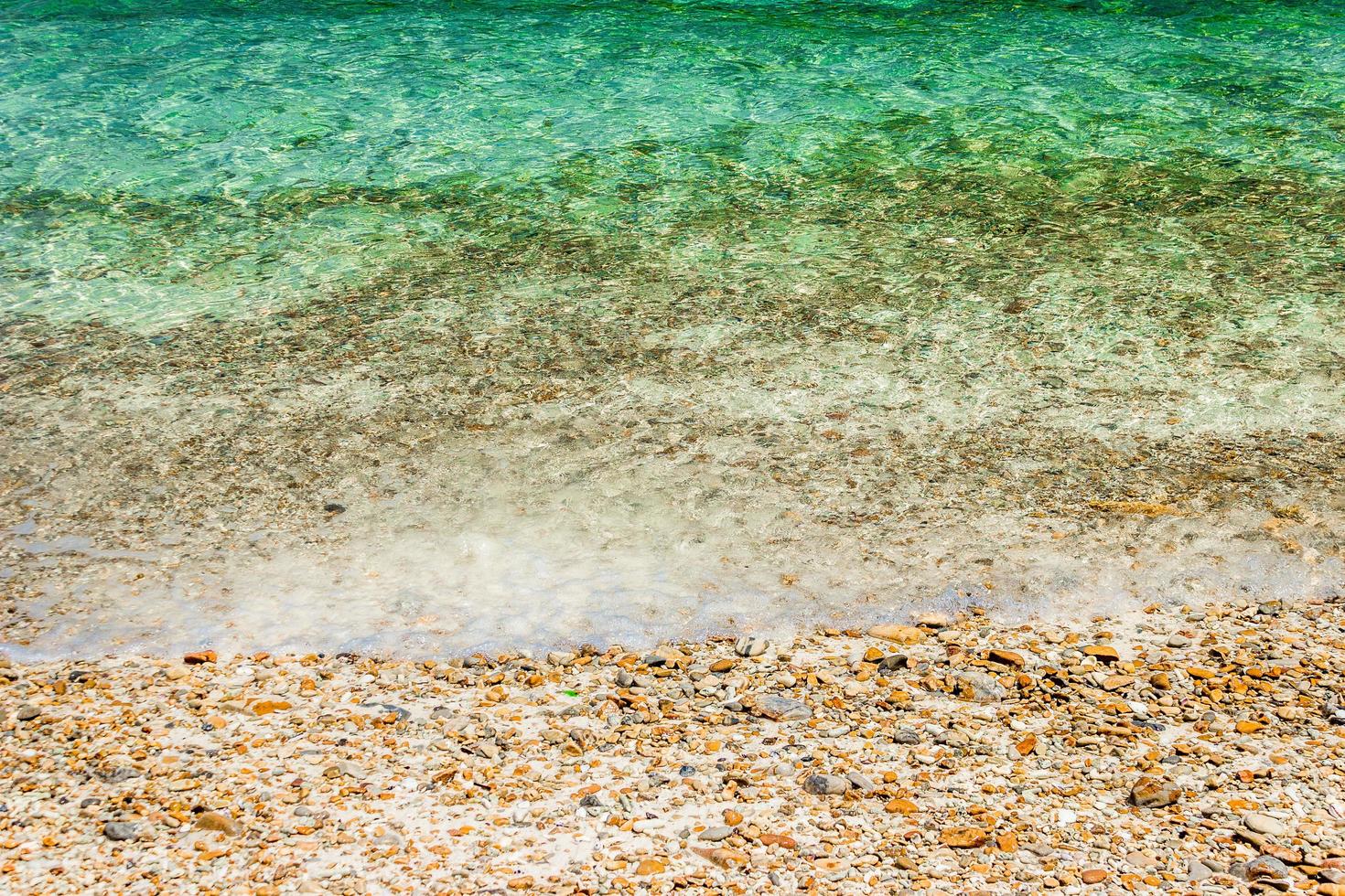 Ocean waves with on pebbles at beach photo