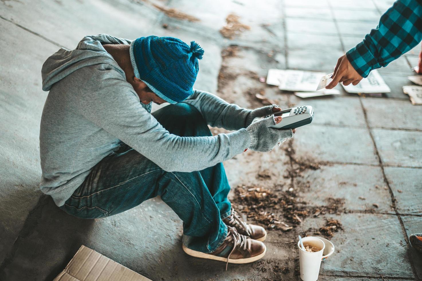 Beggars sitting under the bridge with a credit card swipe machine photo