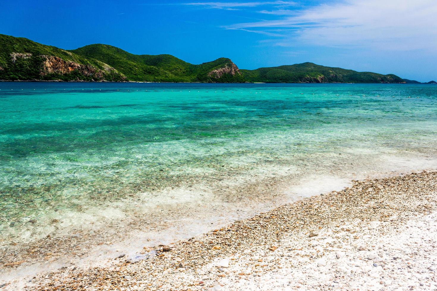 Roca de la isla tropical en la playa con cielo azul nublado foto