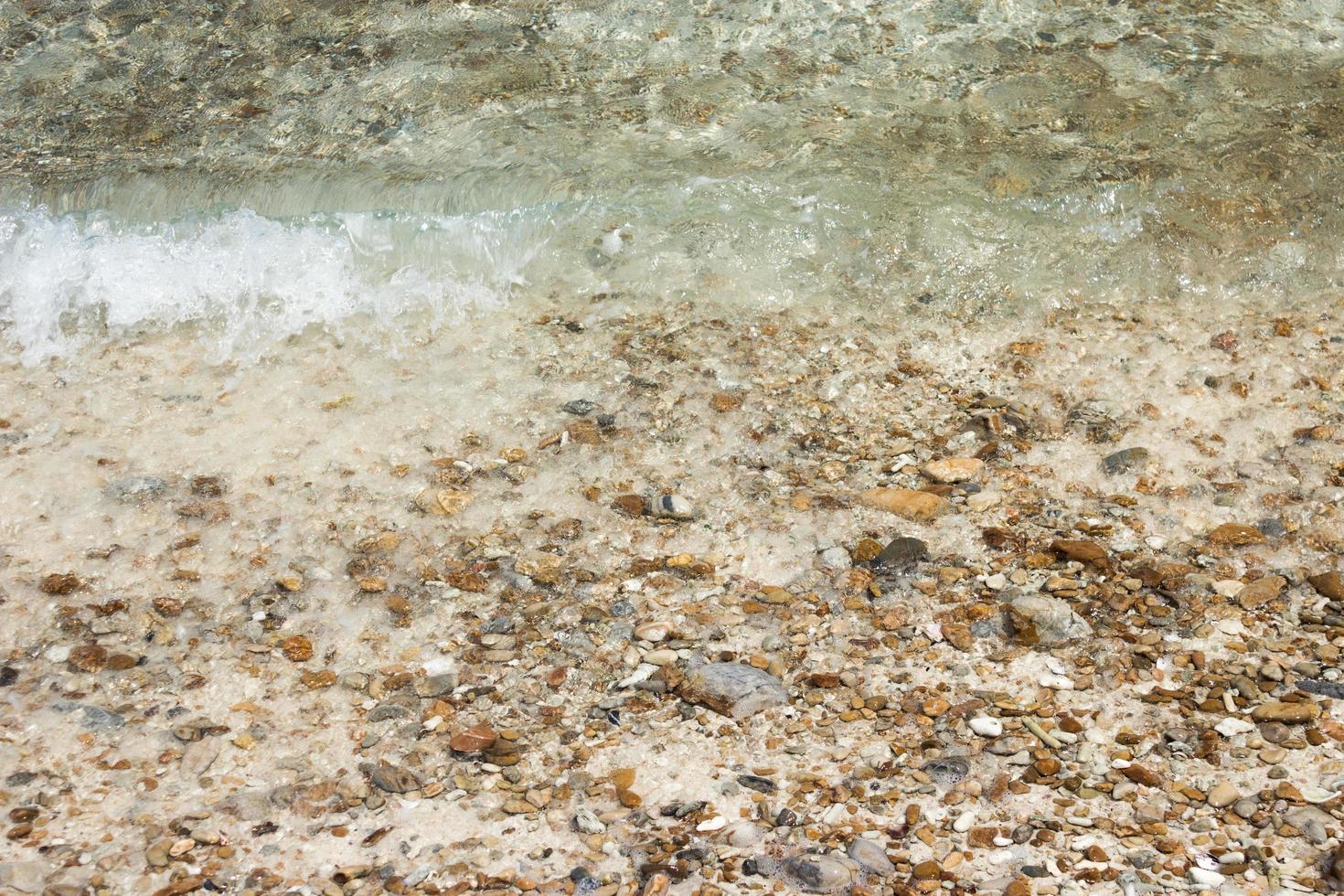 agua sobre guijarros en la playa foto