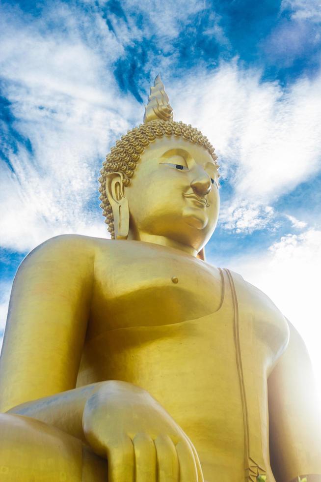 Golden Buddha statue with cloudy blue sky photo