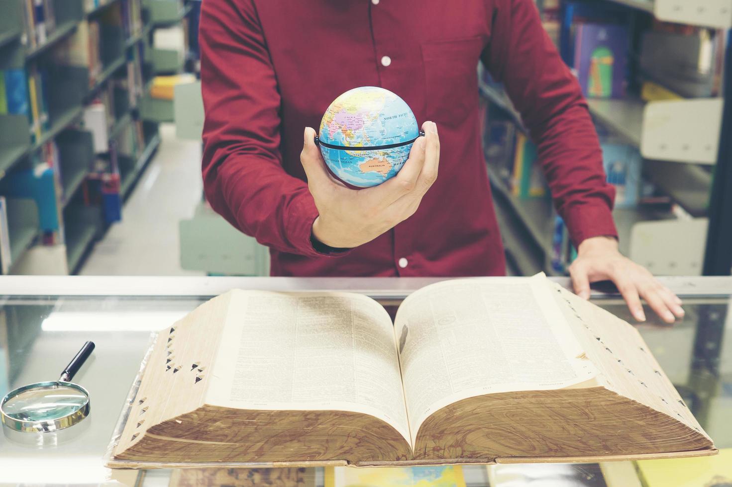 joven estudiante sosteniendo un modelo de tierra en la mano foto