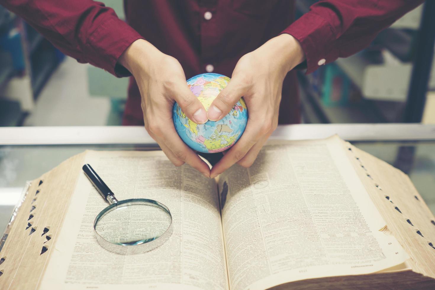 joven estudiante sosteniendo un modelo de tierra en la mano foto