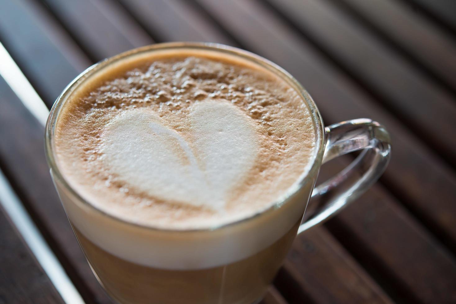 Close-up de taza de capuchino con patrón de leche en forma de corazón foto