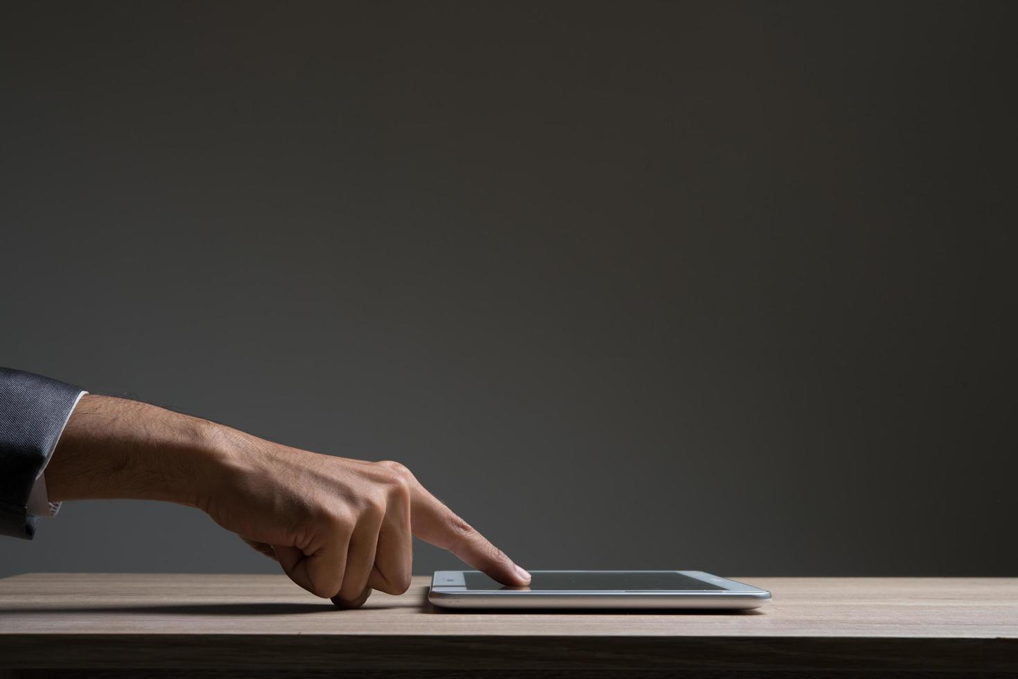 Businessman touching digital tablet and looking on a blank screen photo