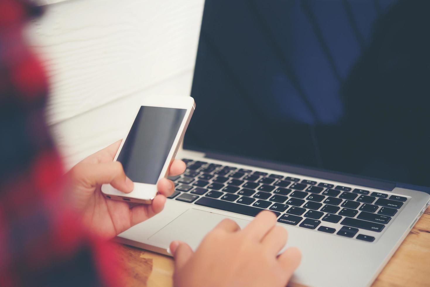 Close-up of young hipster woman using a laptop during a coffee break photo