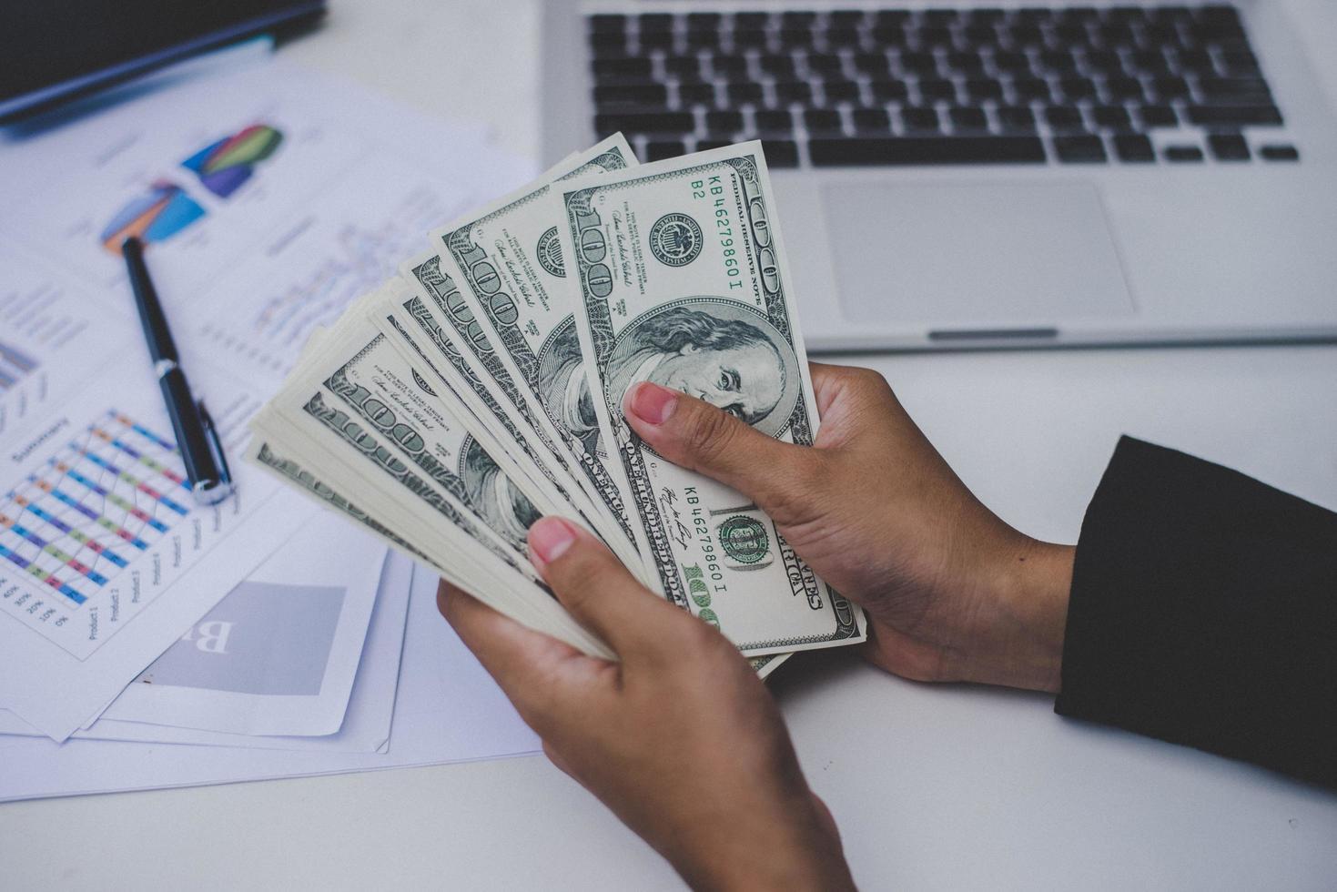 Business woman with dollars, close-up sitting at workplace photo