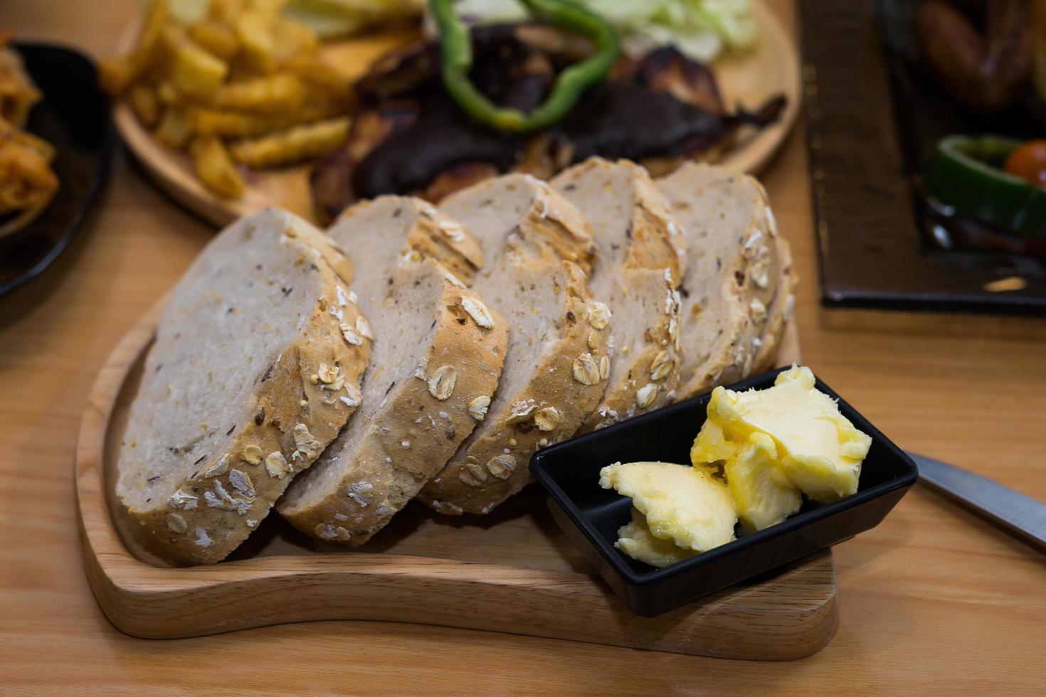 Sliced bread with butter on wooden plate photo