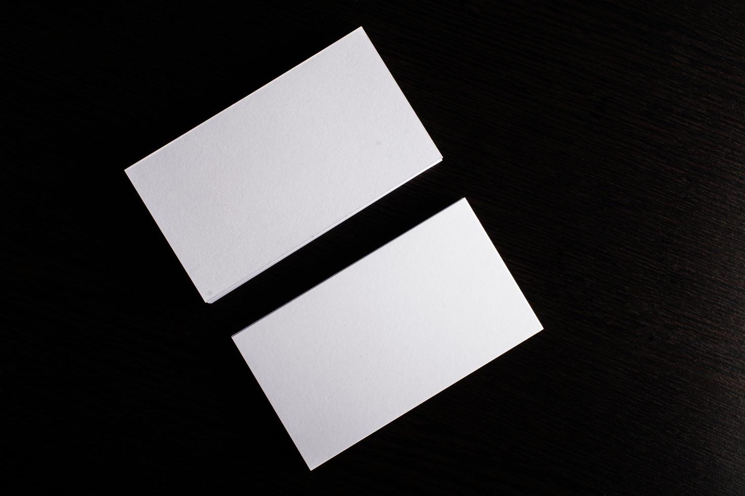Blank white business card on wood background photo