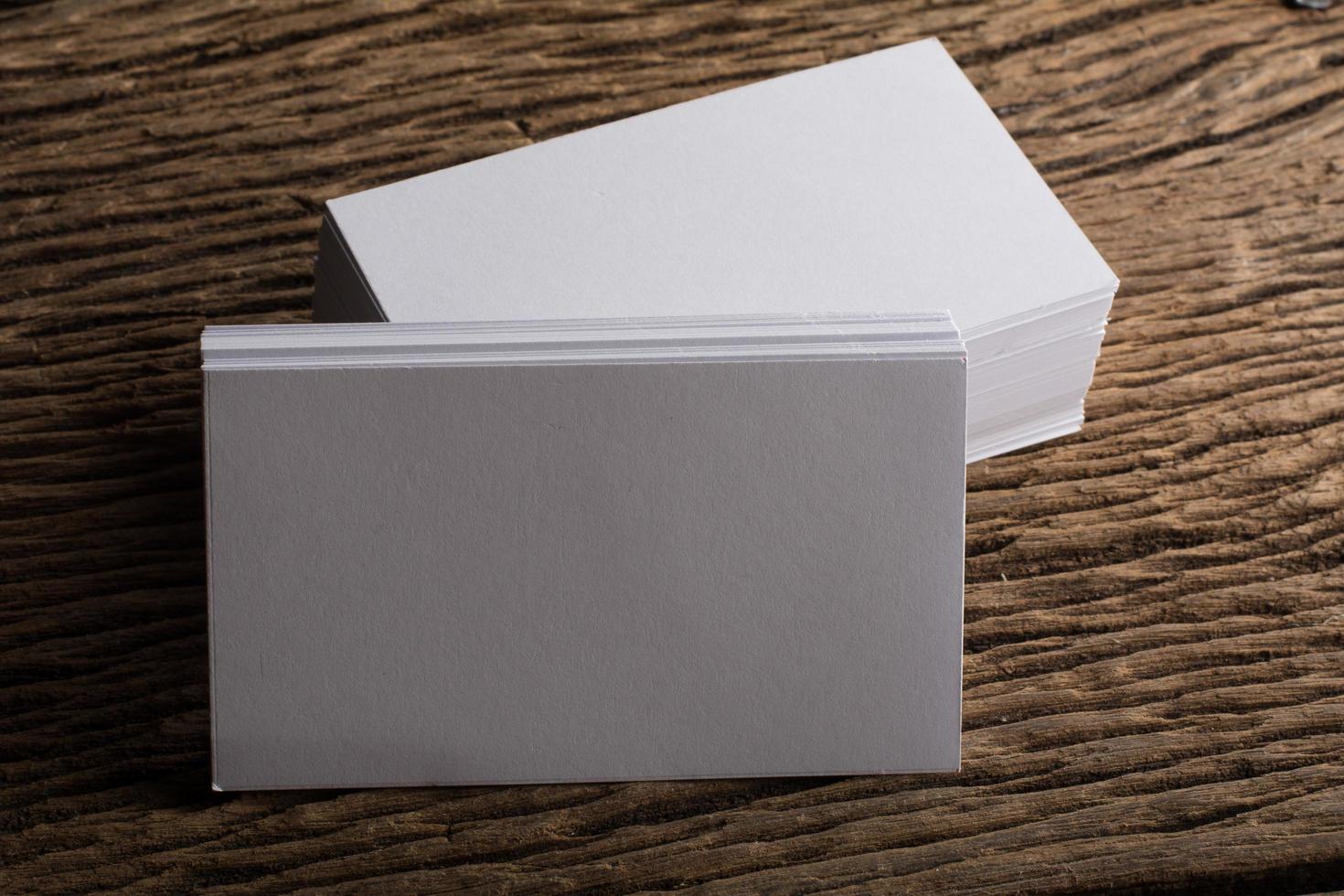 Blank white business card on wood background photo