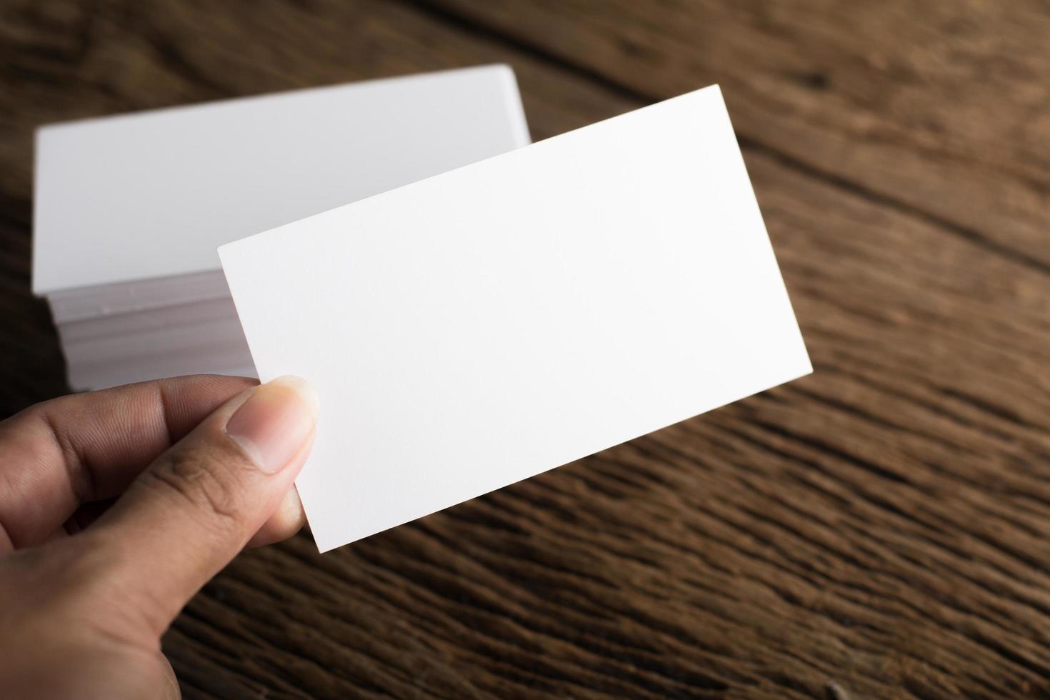 Blank white business card on wood background photo