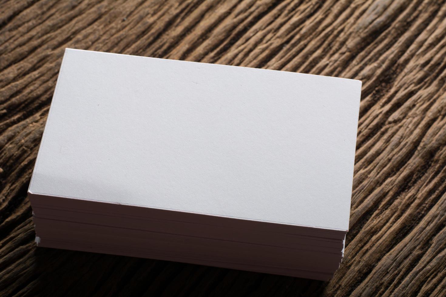 Blank white business card on wood background photo