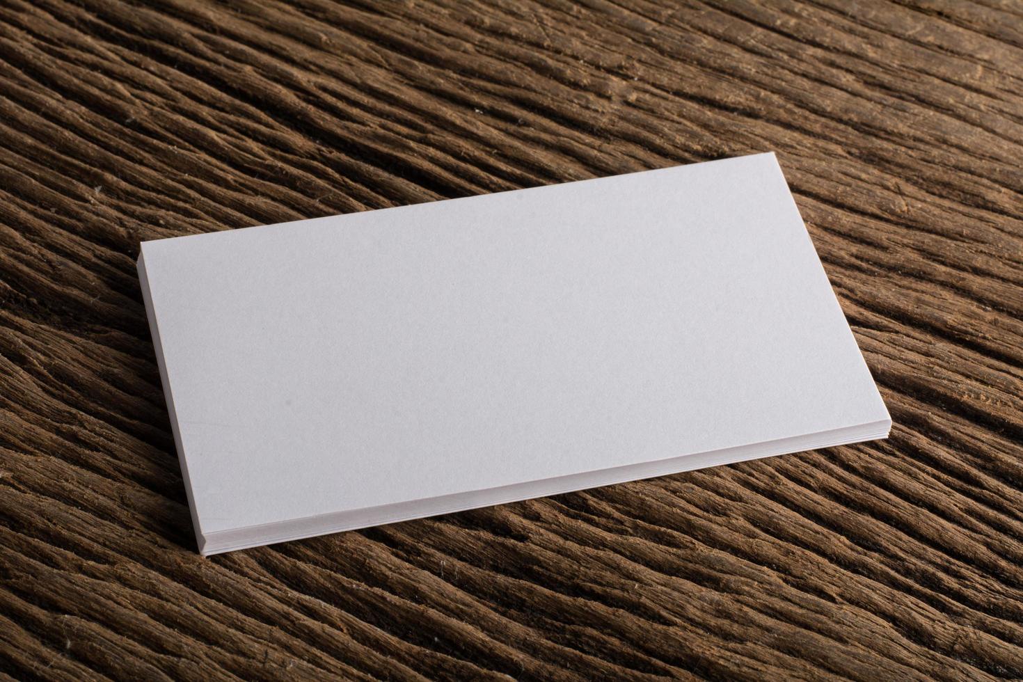 Blank white business card on wood background photo