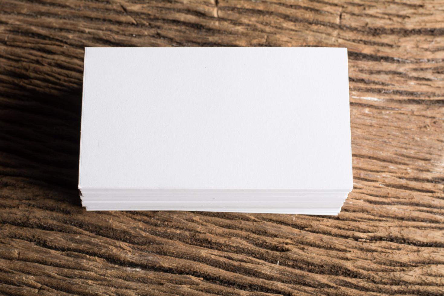 Blank white business card on wood background photo