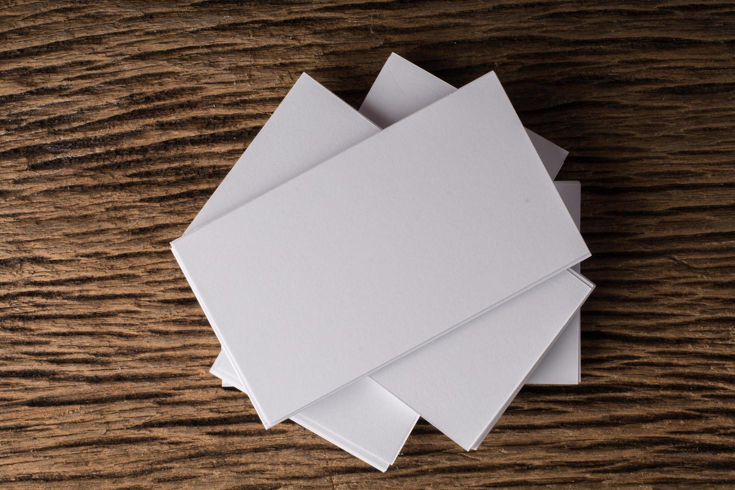 Blank white business card on wood background photo