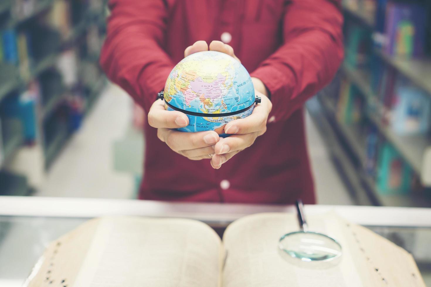 Young student holding earth model in hand photo