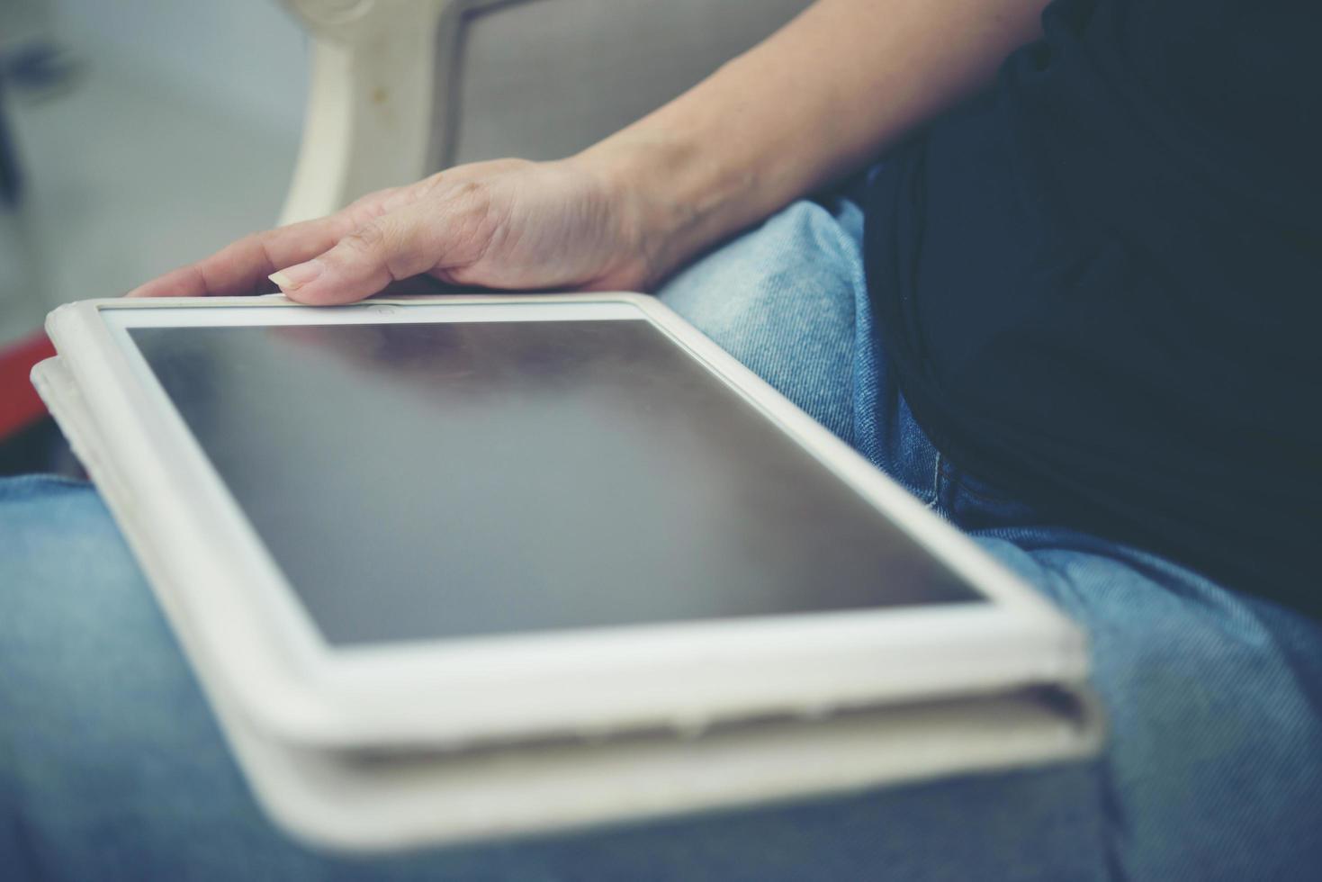 Close-up of hands using tablet sitting and relaxing photo