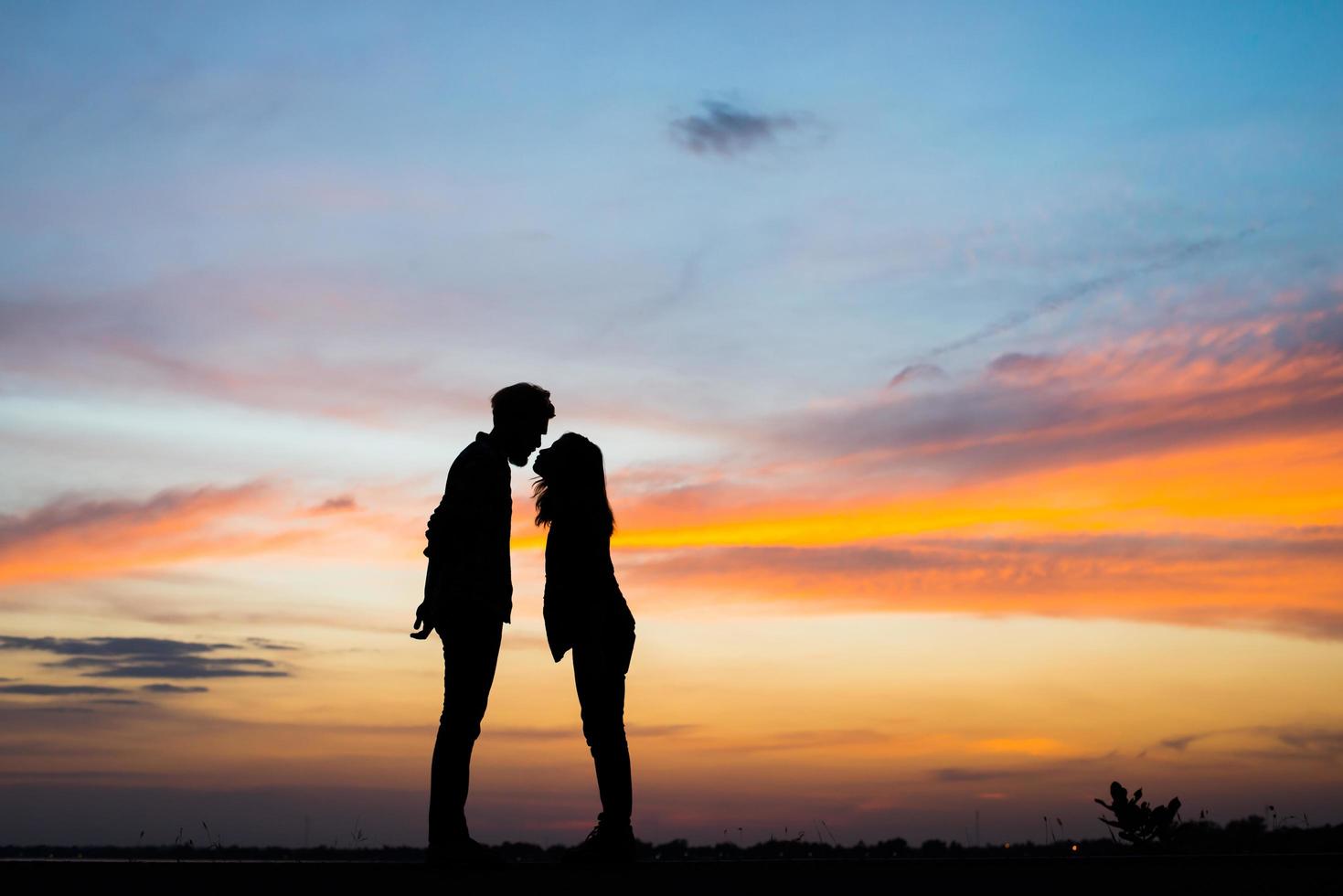 silueta, de, pareja joven, juntos, durante, ocaso foto