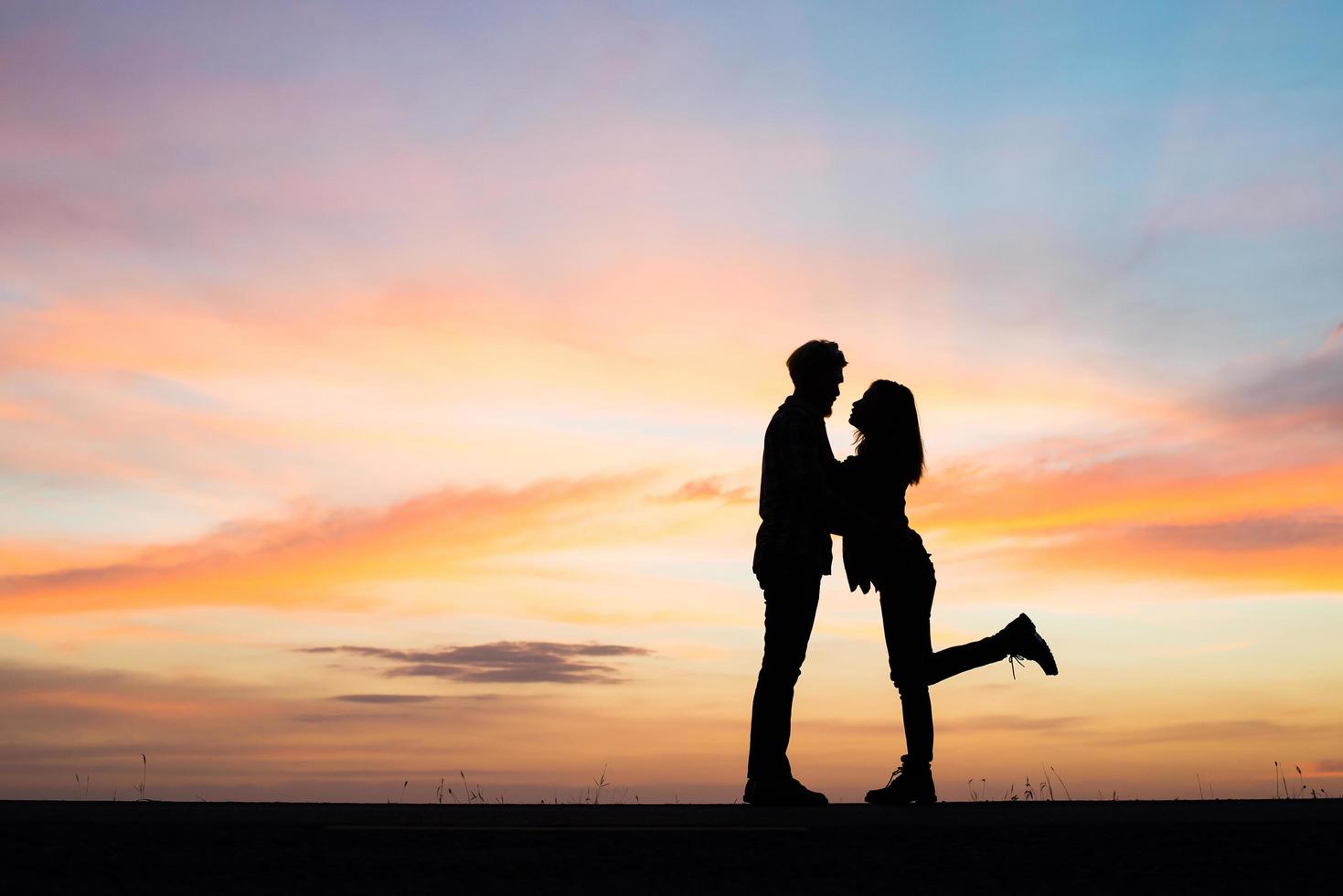 silueta, de, pareja joven, durante, ocaso foto