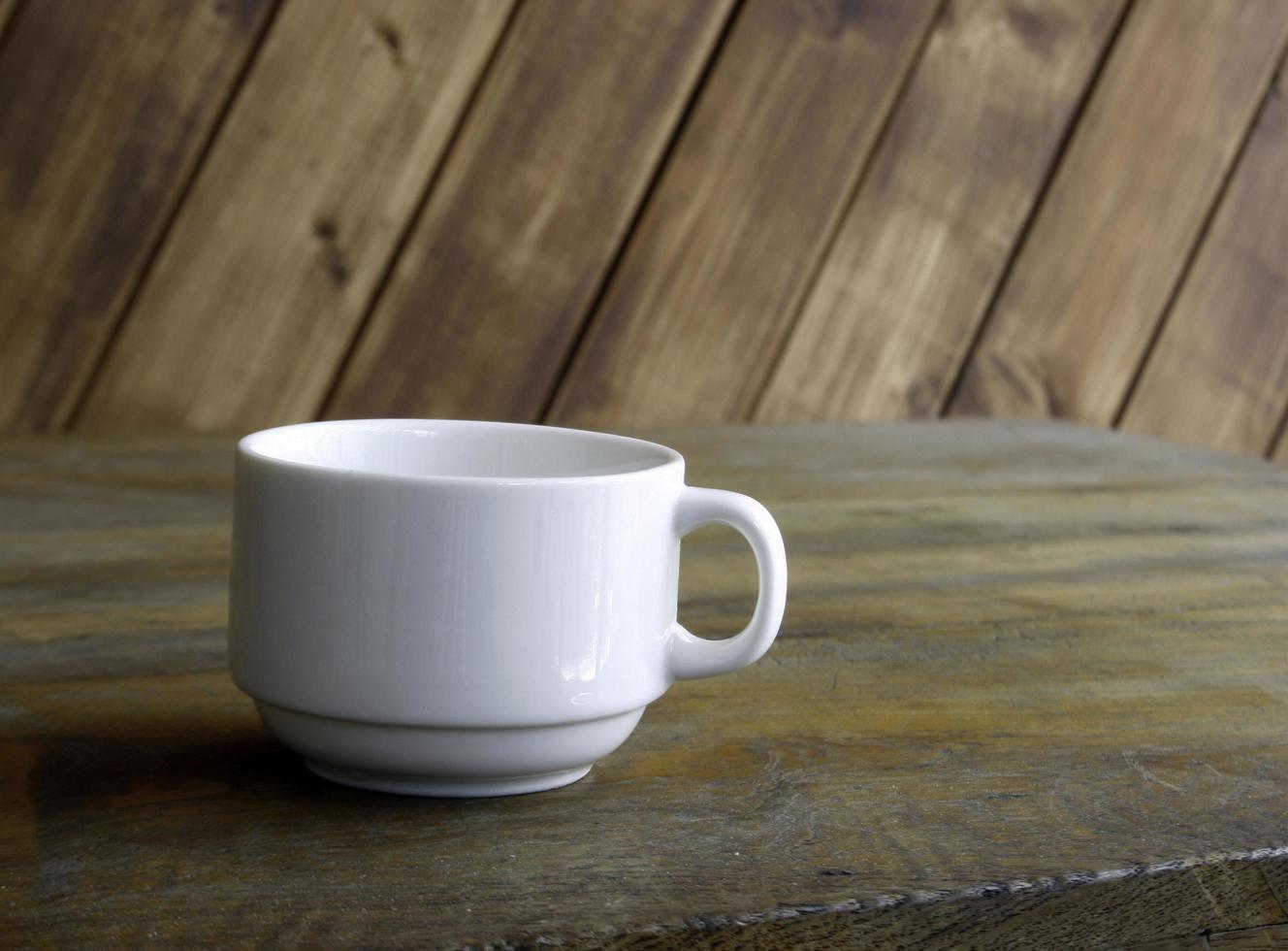 Taza blanca sobre mesa de madera foto