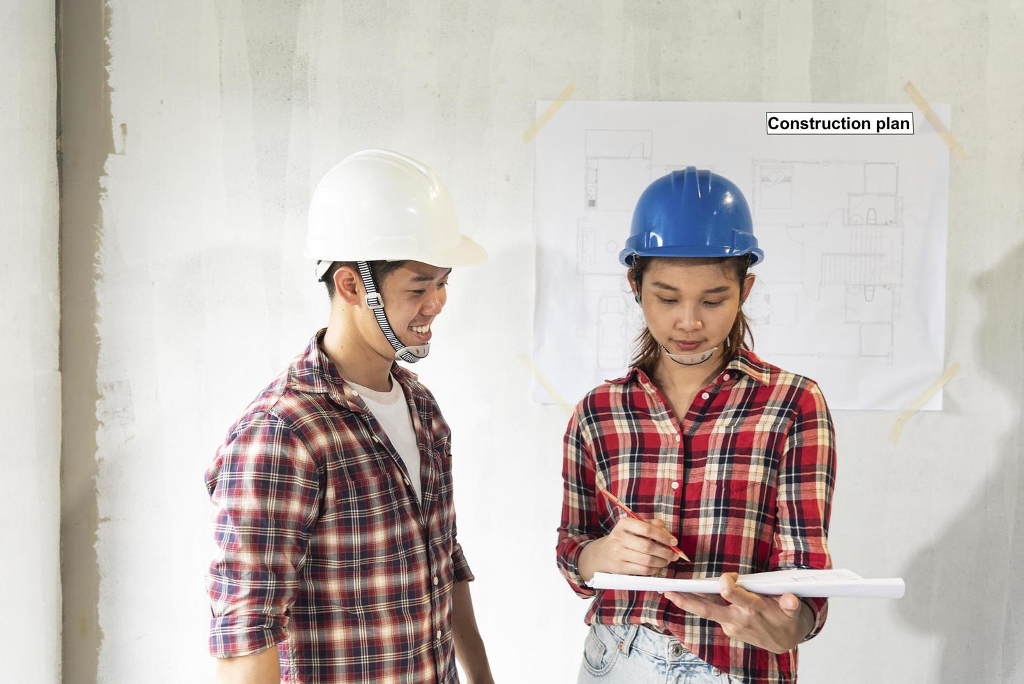 jóvenes ingenieros asiáticos con cascos en foto