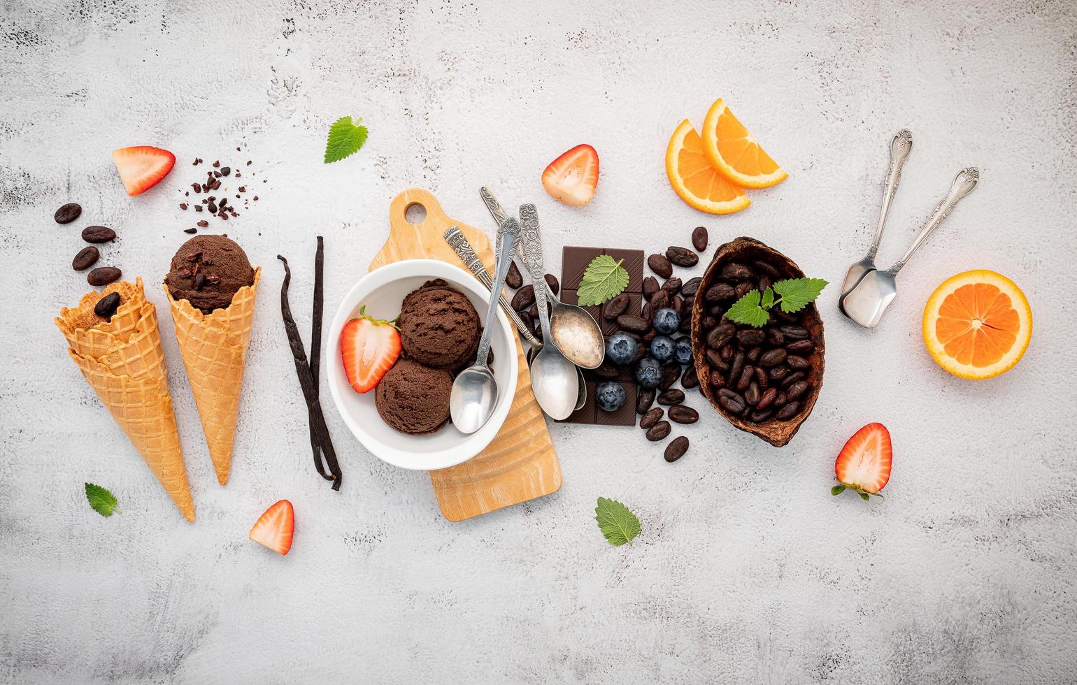 sabores de helado de chocolate en un tazón con chocolate negro y semillas de cacao foto