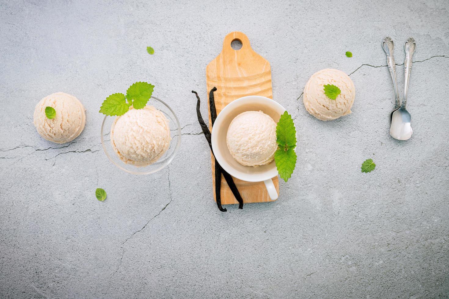 Vanilla ice cream flavor in bowl with vanilla pods on concrete background photo