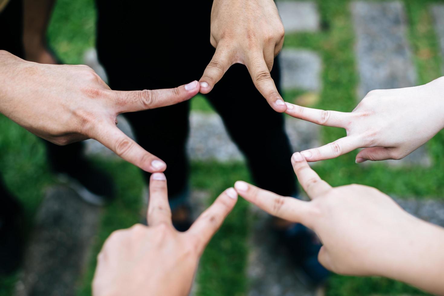 Friends make star shape together from fingers photo