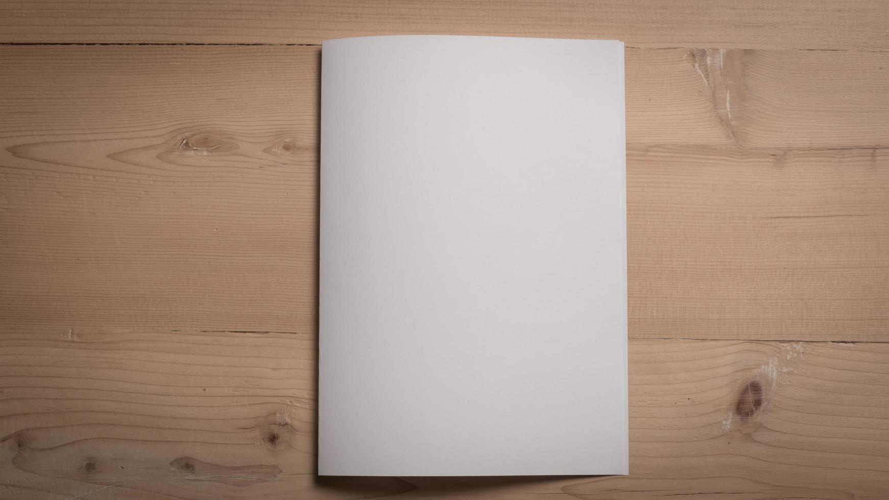 White blank folded paper on wooden table photo