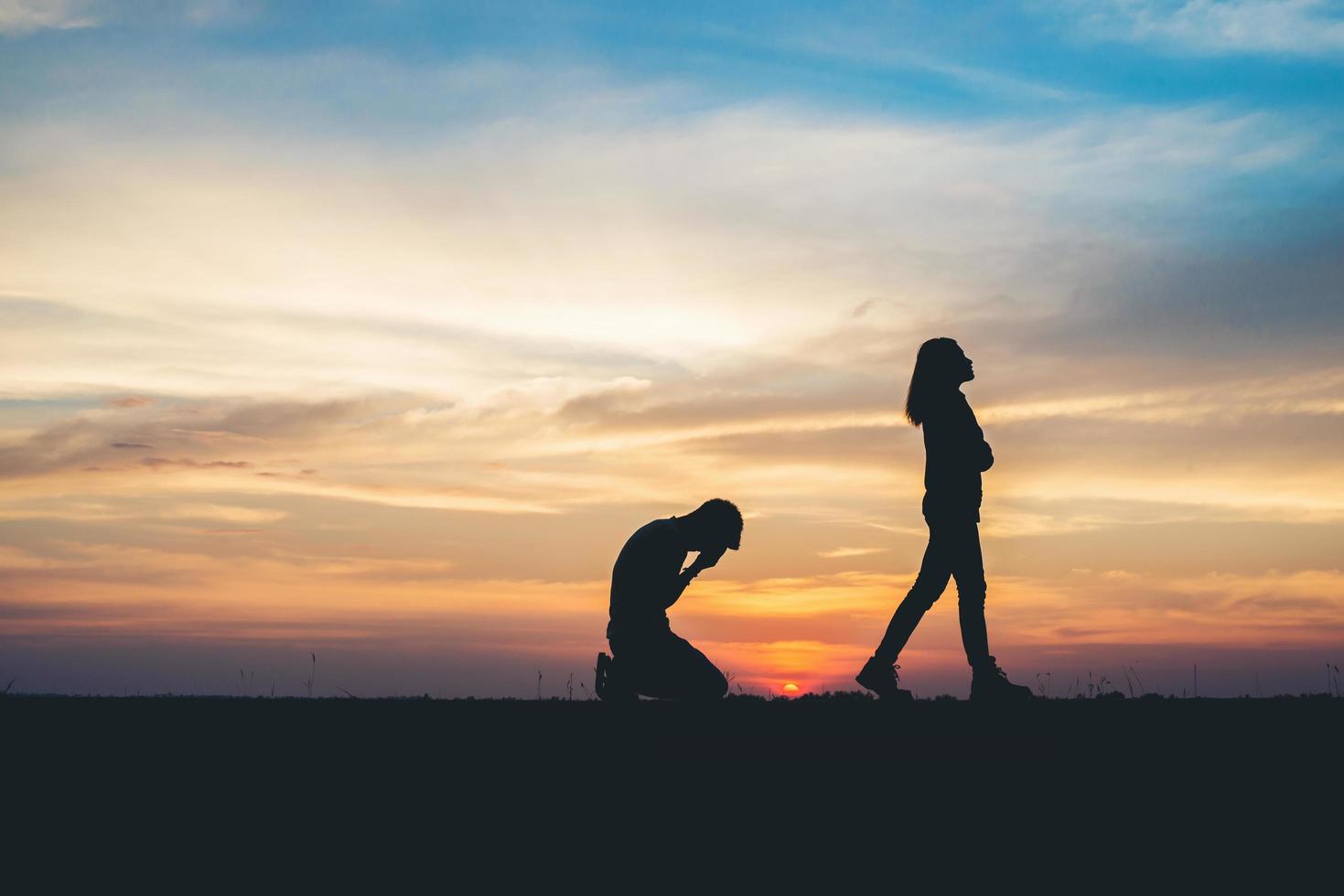 silueta de pareja rompiendo en la carretera al atardecer foto