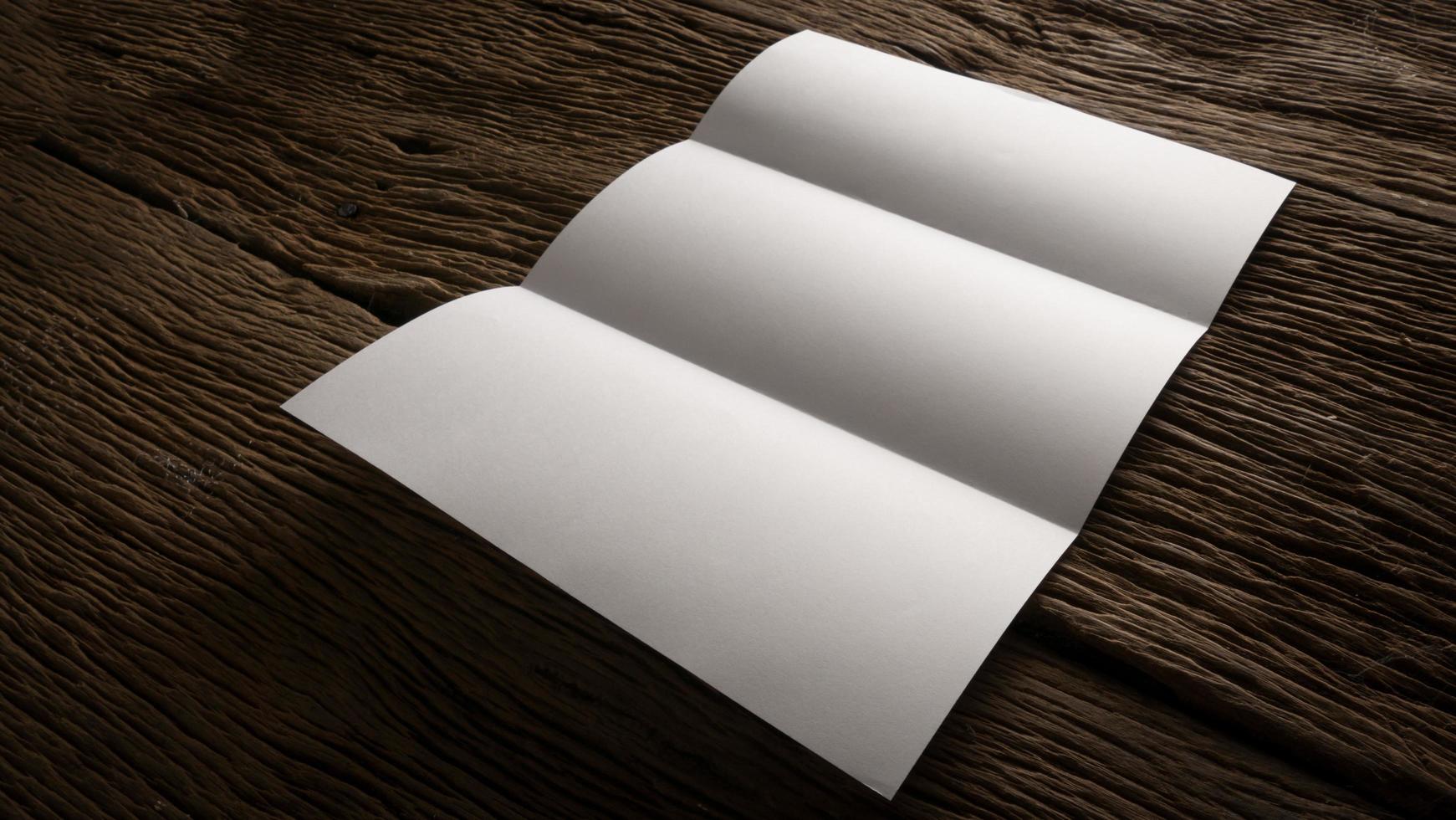 White blank folded paper on wooden table photo