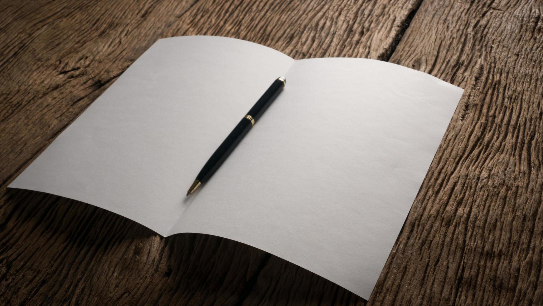 White blank folded paper on wooden table photo